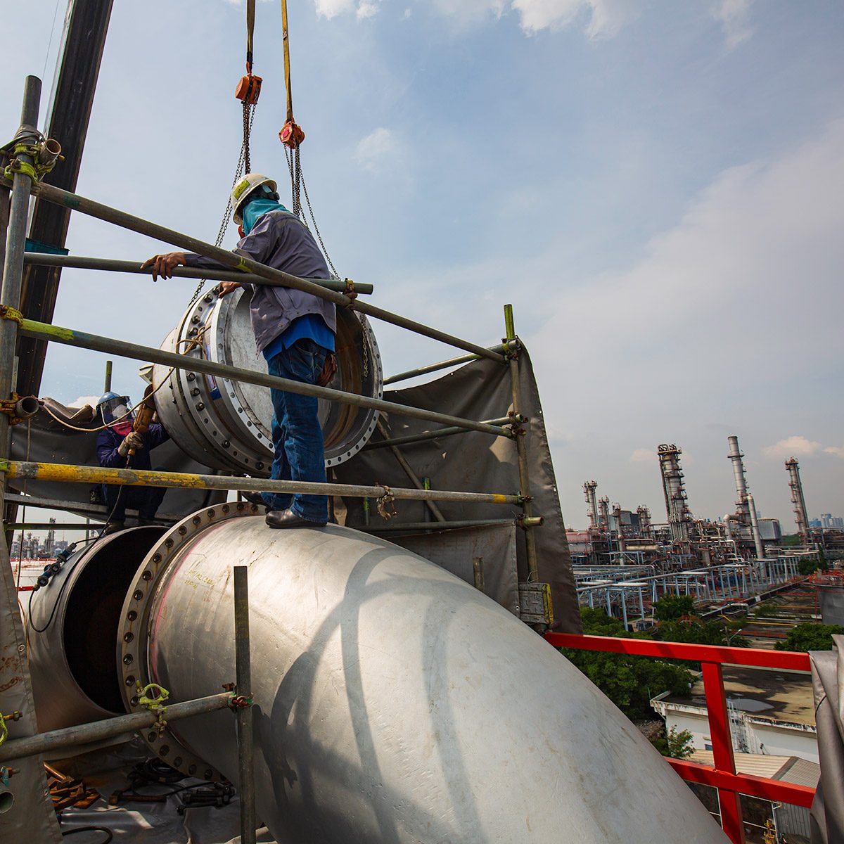 male-worker-slinger-crane-work-unloading-by-crane-production-pipeline-big-oil-valve-equipment